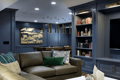 A brightly lit man cave contrasts well with the dark blue paint on the exterior walls and shelving.