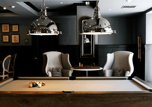 A large pool table in a wide man cave room.